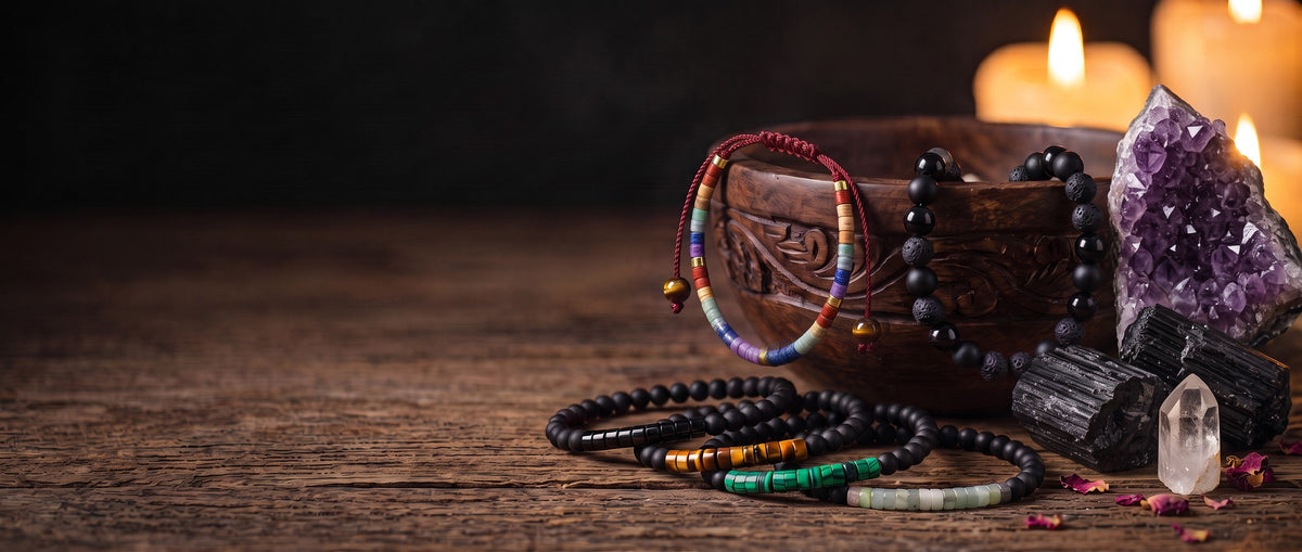 Pulseras de piedras naturales en un cuenco de madera tallada, con drusa de amatista, turmalina negra, cuarzo y velas