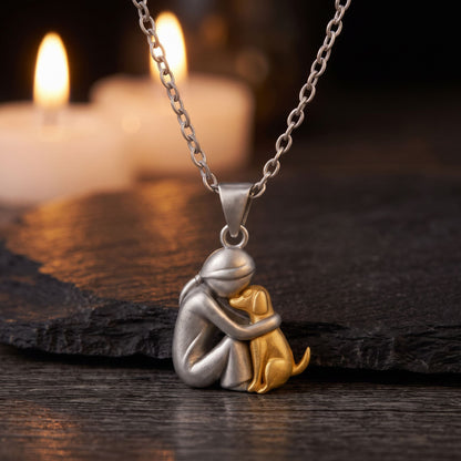 Collar Lazo Eterno, diseño mujer abrazando a su perro, sobre una piedra oscura con velas al fondo